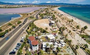 An aerial view of a coastal area with a road, beach, and buildings.