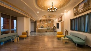 A spacious lobby with a wooden floor, a reception desk, and seating areas. - The Sky Imperial Chotila (Chotila)