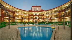 A hotel with a central pool, multiple floors, and a symmetrical design. - The Sky Imperial Chotila (Chotila)