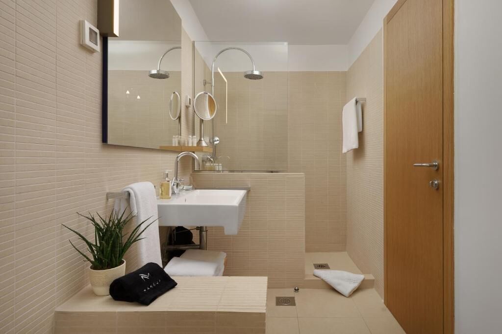 Une salle de bain moderne avec un lavabo, un miroir et une douche.