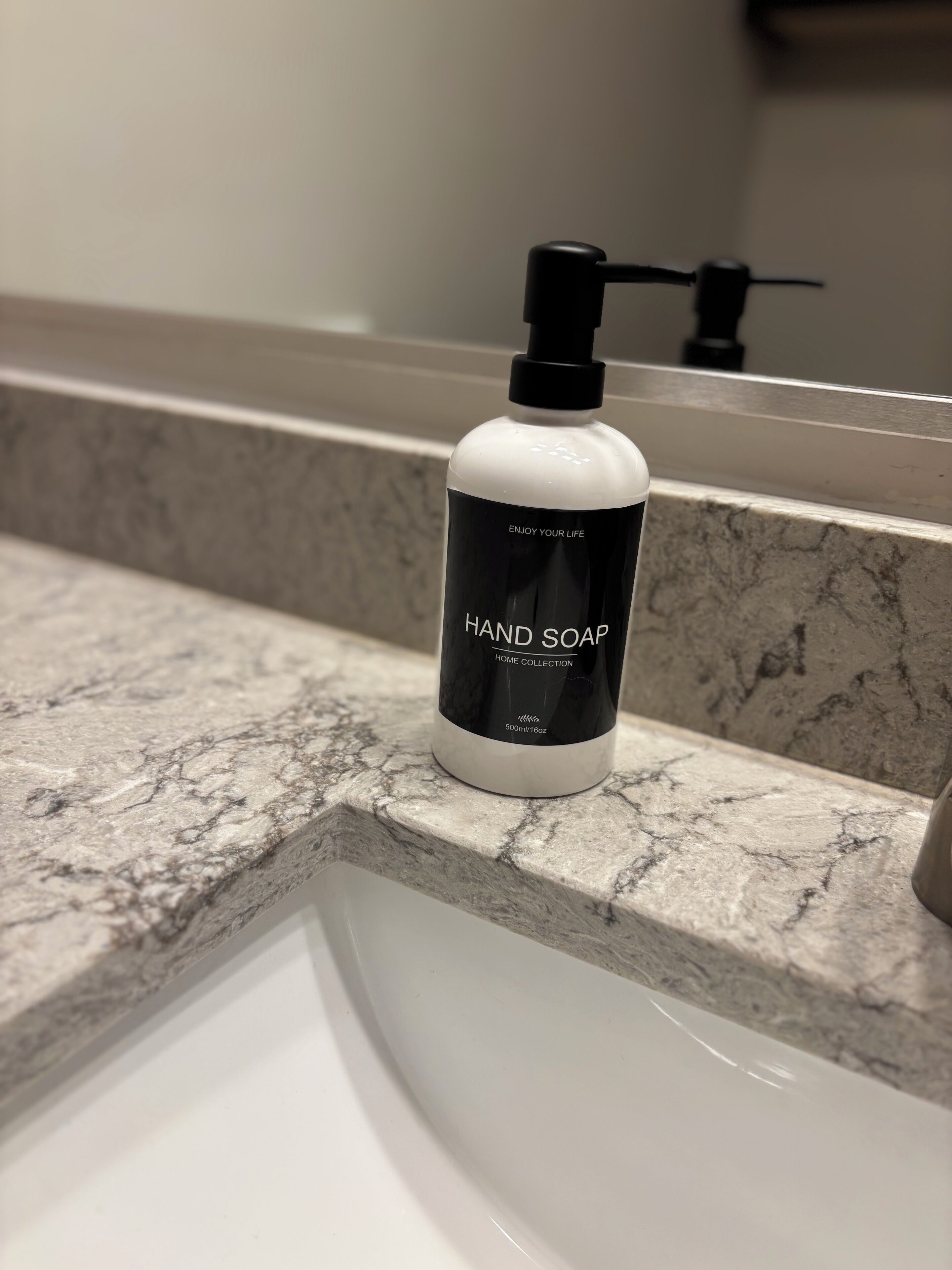 A bottle of hand soap on a bathroom countertop.