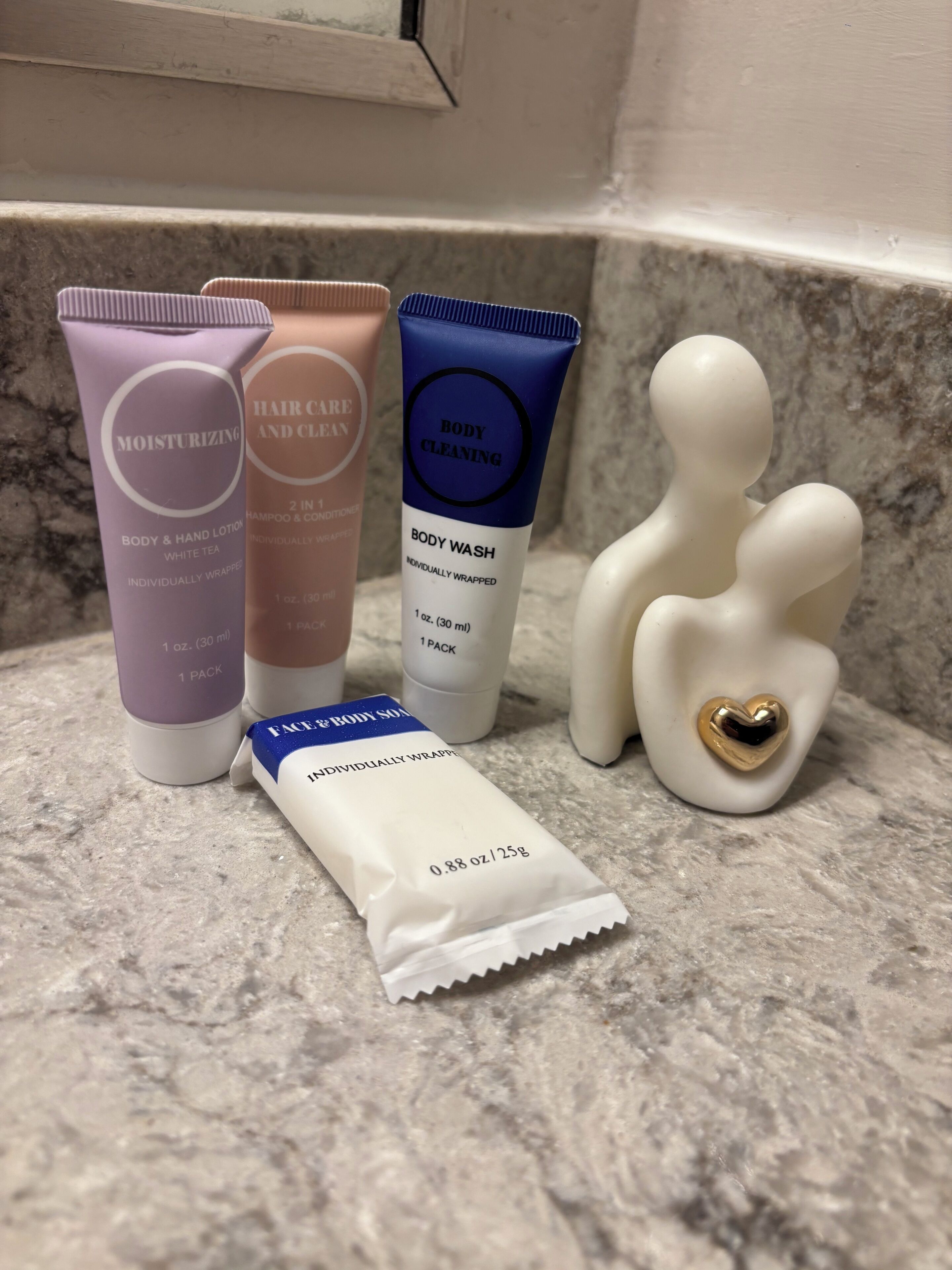 A bathroom counter with various toiletries including body wash, shampoo, and lotion.