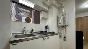 Una cocina con pileta, estufa y sistema de ventilación.
