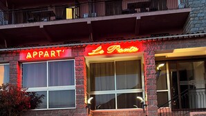 A building with a brick facade, a neon sign reading "Le Parto", and a staircase leading to an upper level. - Very pleasant apartment with sea and mountain views, boat trip (Ota)