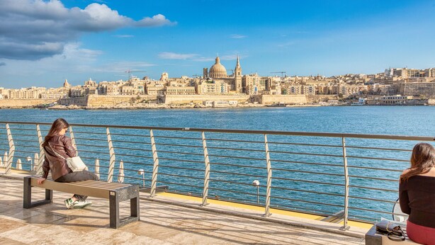 Une promenade en bord de mer, agrémentée de bancs d’où l’on peut admirer le paysage urbain.