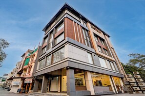 A multi-story building with a modern design, featuring large windows and a corner entrance. - The Byke Boutique Urban Nest (Bhopal)