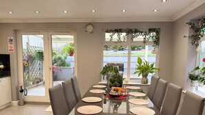 A dining area with a rectangular table, six chairs, and a clock on the wall. - Peaceful, Spacious Home Minutes from Centre (Chester)
