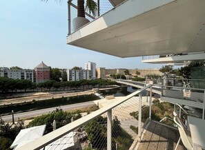 Een modern gebouw met een dakterras met uitzicht op een rivier en stadsbeeld.