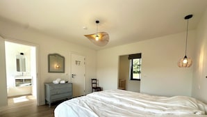 A bedroom with a large bed, a dresser, a mirror, and a ceiling fan. - Ferme Valentour 24 beds, ideal for families and corporate seminars. (Gesves)