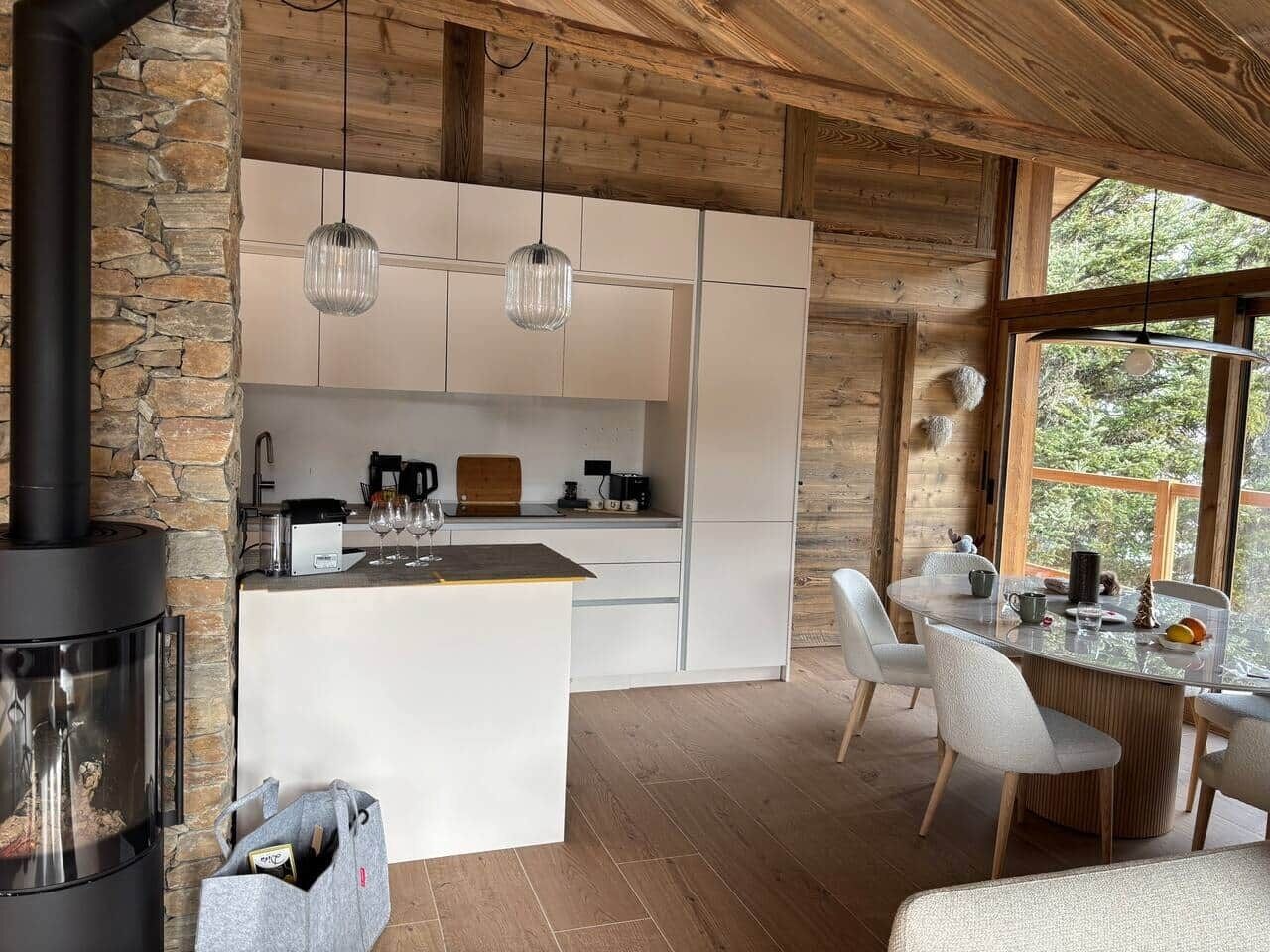 A modern kitchen with a central island, white cabinetry, and pendant lighting.
