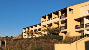 A multi-story building with balconies, a flat roof, and a hillside backdrop. - VVF Hyères presqu'île de Giens (Hyères)