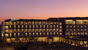 A multi-story hotel with a modern design, featuring a prominent sign for 'Radisson' and a section labeled 'Level Seven'. - Radisson Hotel And Convention Center Steve Tshwete Middelburg (Middelburg)