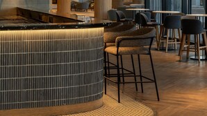 A modern interior with a central bar area, seating arrangements, and large windows allowing natural light. - Radisson Hotel And Convention Center Steve Tshwete Middelburg (Middelburg)