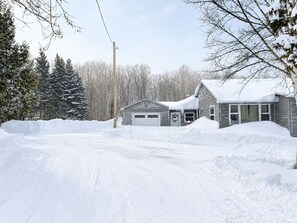 A snow-covered residential area with a garage, a house, and a large pile of snow in the foreground. - NEW-Pictured Rocks Paradise!
Near Pictured Rocks & Lake Superior! (Shingleton)
