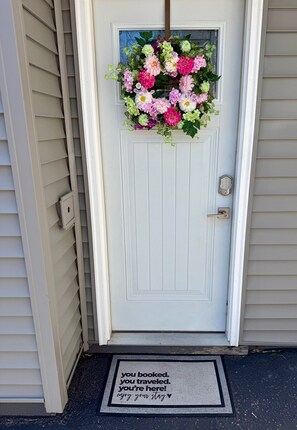 A white door with a floral wreath, a doorbell, and a doormat with a message. - NEW-Pictured Rocks Paradise!
Near Pictured Rocks & Lake Superior! (Shingleton)