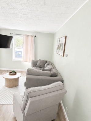 A living room with a sofa, a round coffee table, a flat-screen TV, and a window with curtains. - NEW-Pictured Rocks Paradise!
Near Pictured Rocks & Lake Superior! (Shingleton)