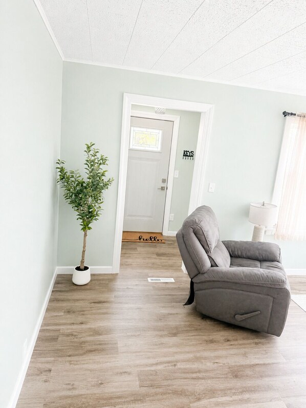 A room with a grey sofa, a potted plant, a door with a sign, and a window with curtains. - NEW-Pictured Rocks Paradise!
Near Pictured Rocks & Lake Superior! (Shingleton)