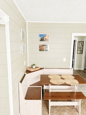 A dining area with a wooden bench and table, framed pictures on the wall, and a door leading to another room. - NEW-Pictured Rocks Paradise!
Near Pictured Rocks & Lake Superior! (Shingleton)