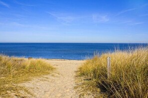 A sandy beach path leading to the ocean with tall grass on either side. - Château Margaux – A Soothing 3‑Bedroom Country House in Charming Norfolk (Norfolk)