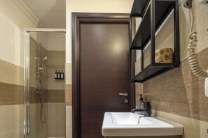 A bathroom with a glass shower enclosure, a sink with a mirror above it, and a towel rack. - BuddyRent - Ghetto - Campo de' Fiori - 6 ospiti (Roma)