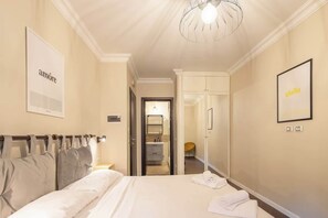 A hotel room with a bed, a wardrobe, a bathroom, and a hallway leading to another room. - BuddyRent - Ghetto - Campo de' Fiori - 6 ospiti (Roma)