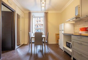 A compact kitchen with a dining area, a view to the outside, and a modern design. - BuddyRent - Ghetto - Campo de' Fiori - 6 ospiti (Roma)