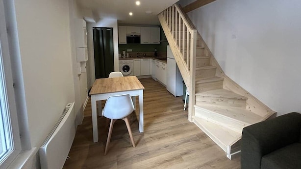 A modern apartment with a dining area, kitchen, and staircase. - Les Coteaux III (Gérardmer)