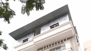 Un immeuble à plusieurs étages, sur lequel on peut lire l’enseigne « Aditya Guest House » et où figure un numéro de téléphone.