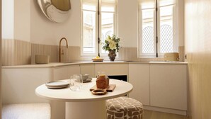 A modern kitchen with a round dining table, a built-in oven, and a window with a view. - Luxurious Astorg Residence (Paris)