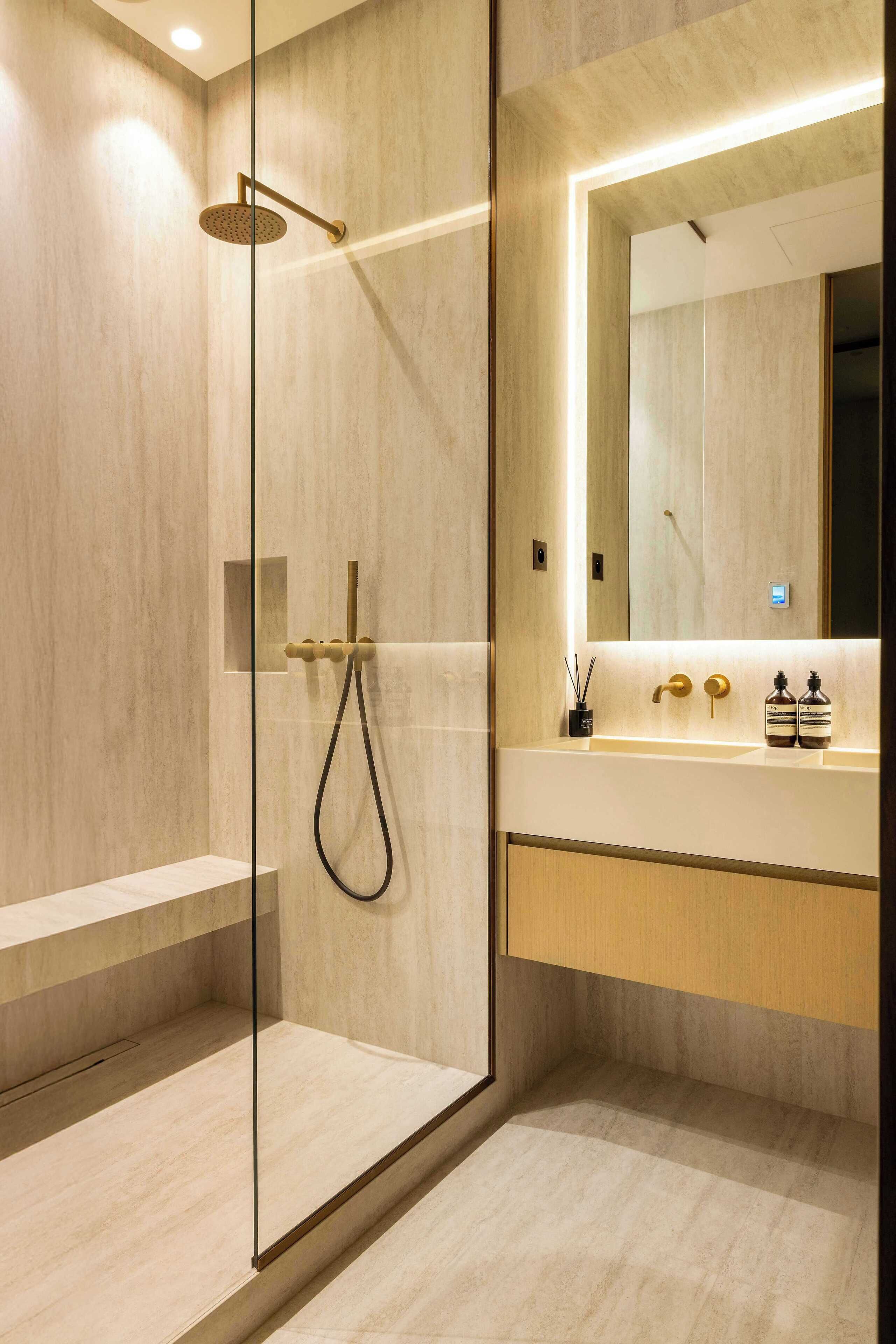 A modern bathroom with a glass-enclosed shower, a vanity with a mirror, and a wooden cabinet.