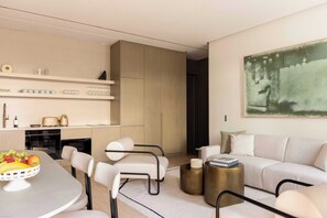 A modern living room with a dining area, a sofa set, and a kitchen with built-in appliances. - Luxurious Astorg Residence (Paris)