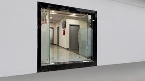 Un couloir avec une porte vitrée donnant sur une pièce.
