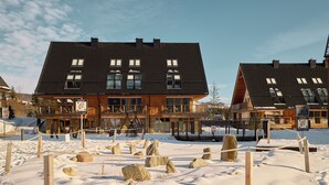 Un hôtel avec un toit sombre, de nombreuses fenêtres et une façade en bois.