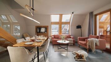 Un salon moderne avec un coin repas, de grandes fenêtres et un chien qui se repose sur le sol.