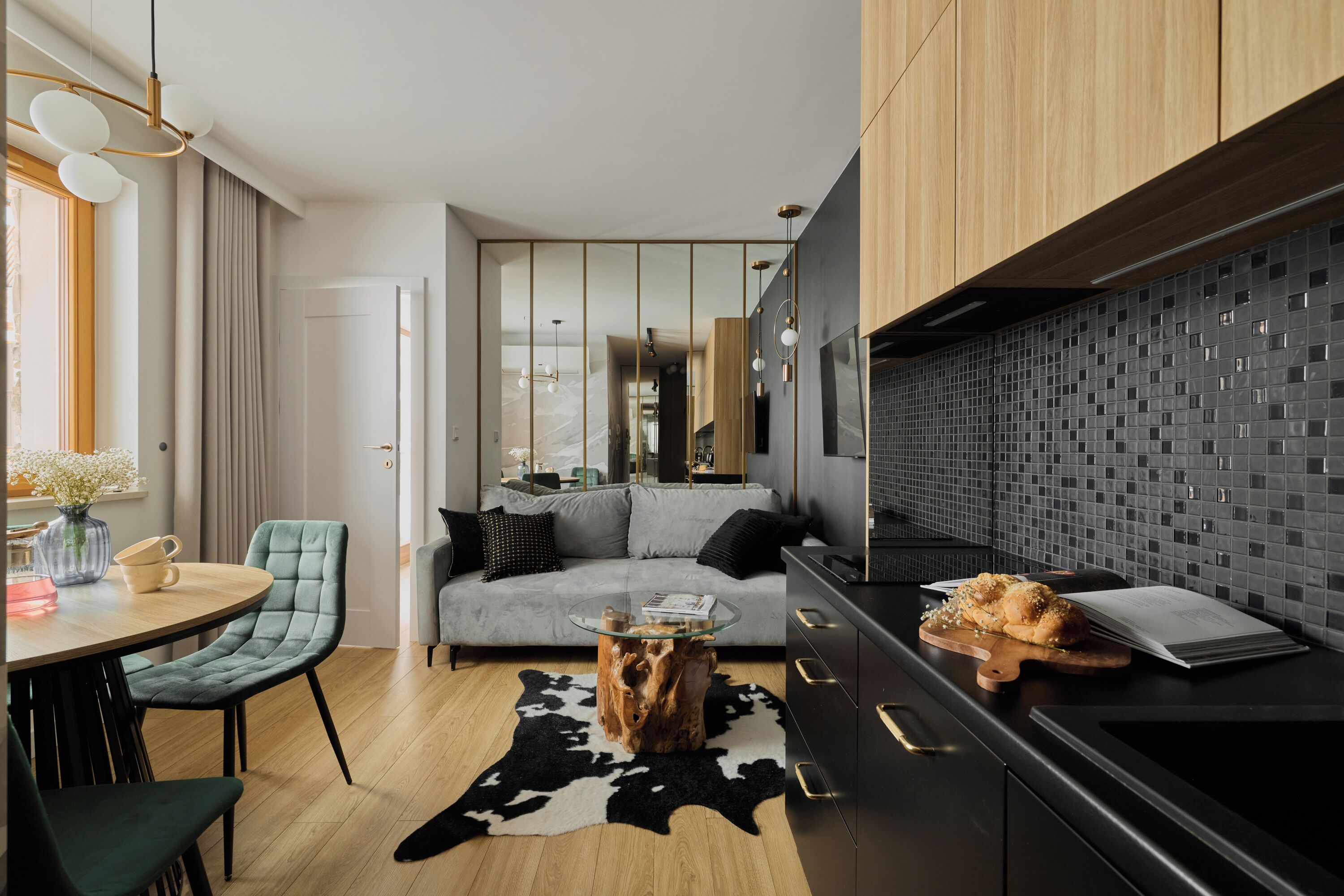 A modern living space with a sofa, a coffee table, and a dining area with chairs.