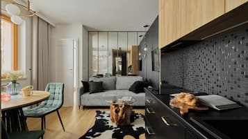 A modern living space with a sofa, a coffee table, and a dining area with chairs.