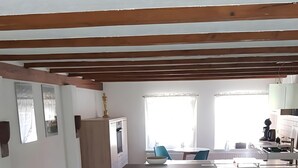 A spacious kitchen with a central island, two bar stools, a blue rug, and a woven rug on the floor. - Gut Belgerhof Steinbach Holiday Apartment (Steinbach)