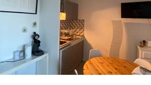 Une cuisine de taille réduite avec une table en bois et des placards blancs.