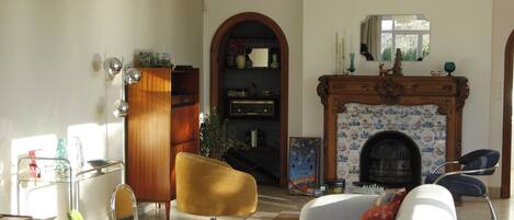 Una sala de estar con chimenea, un sofá, una silla y una mesa de centro.