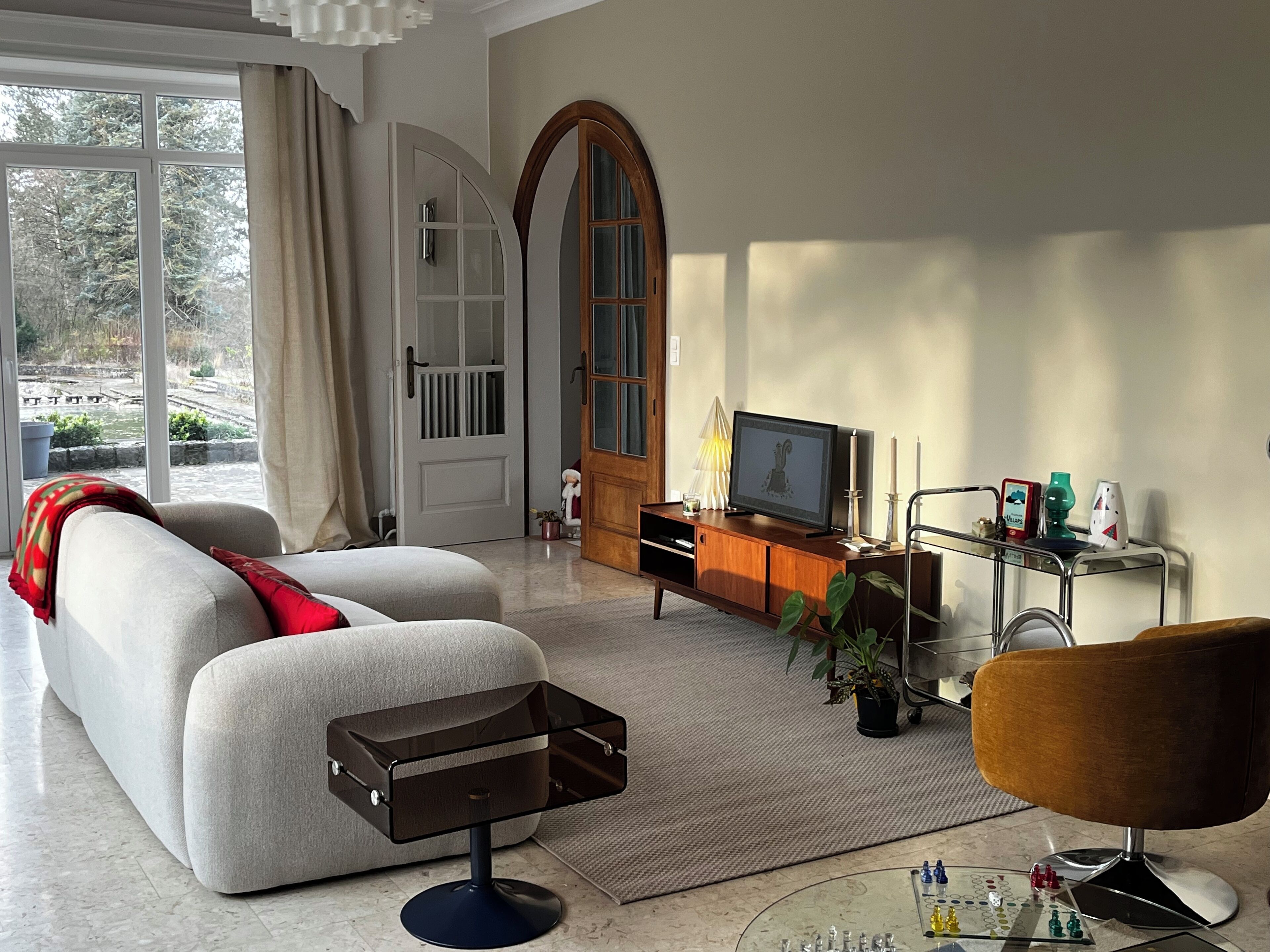 A modern living room with a sofa, a coffee table, a TV, and a chessboard.