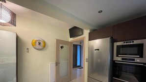 Une cuisine compacte équipée d’un réfrigérateur, d’un four et d’un four à micro-ondes.