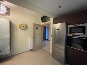 Cocina compacta con refrigerador, horno y microondas.