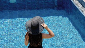 Una persona de pie junto a una piscina de agua cristalina.