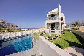 A modern two-story building with a pool and outdoor seating. - Lamon (Agios Vasileios)