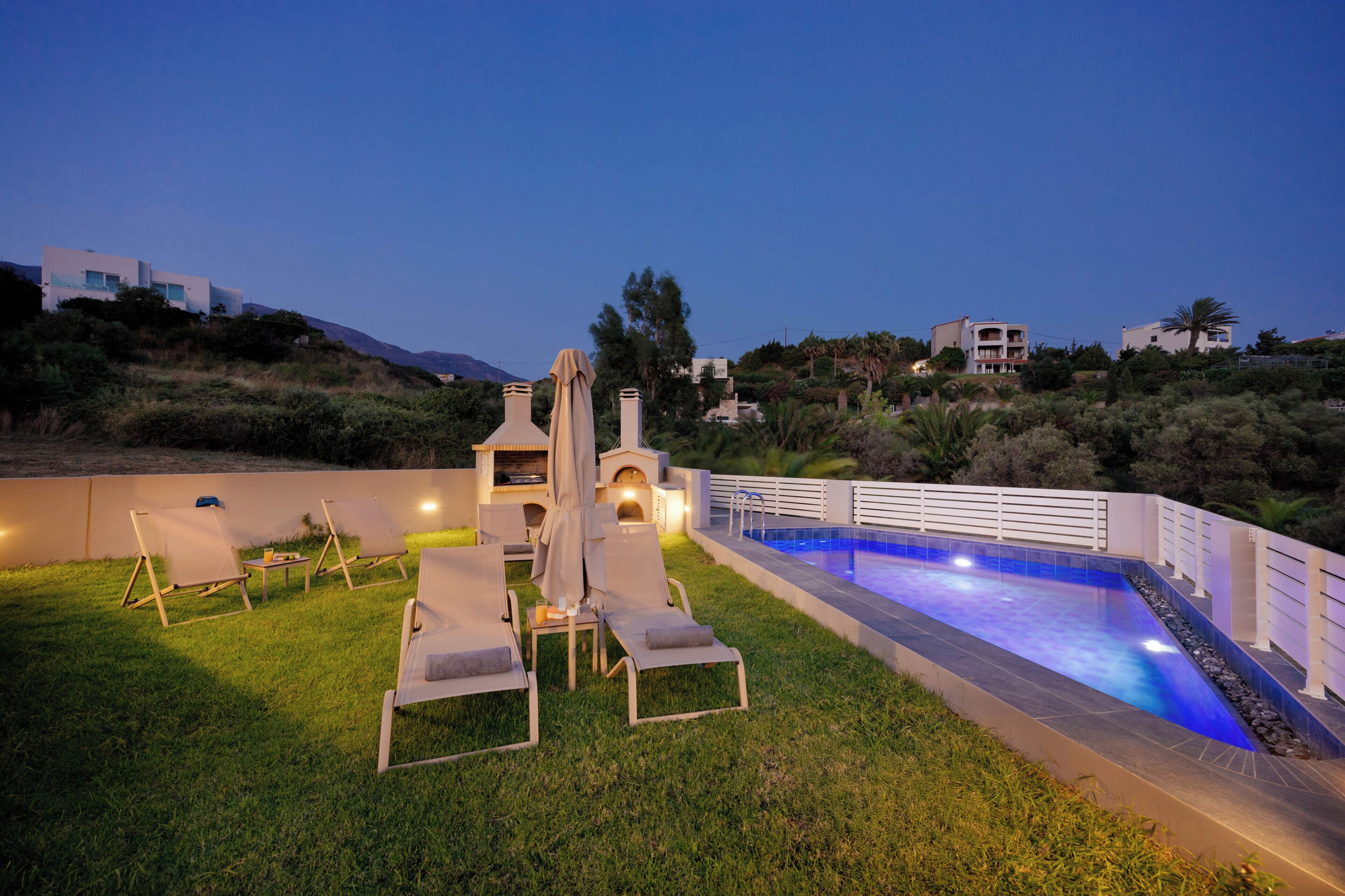 A poolside area with lounge chairs and a barbecue grill.