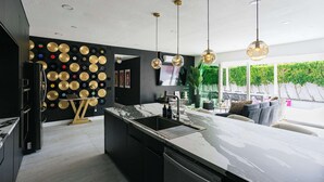 Una cocina moderna con encimera de mármol, pileta integrada y un reproductor de discos de pared.