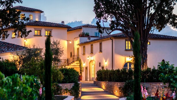 A multi-story building with a stone pathway leading to the entrance, surrounded by lush greenery and flowering plants. - VILLA ARTIUM - Twenty Bedroom Villa, Sleeps 37 (Firenze)
