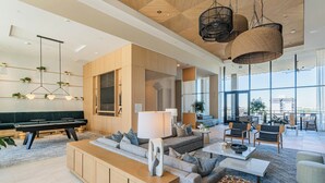 A modern living room with a sofa, coffee table, and a dining area. - 1117 Saiya  (Phoenix)