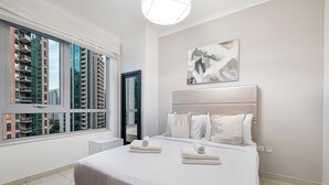 Een moderne slaapkamer met een groot bed, uitzicht op wolkenkrabbers en een eigentijdse kunstwerk aan de muur.