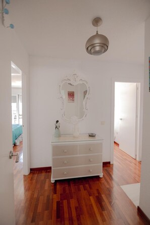 A room with a white dresser, a large mirror, and a ceiling fan. - Apartment 'Melina' with Sea View, Wi-Fi and Air Conditioning (Cala del Moral)